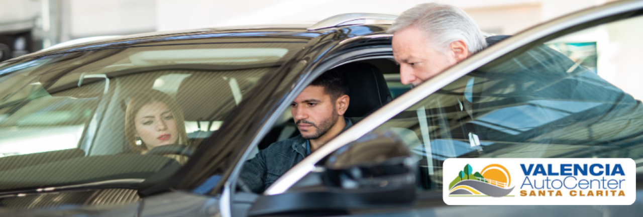 A photo to portray a friendly salesperson assisting a customer in choosing an affordable used electric car at Valencia Auto Center.