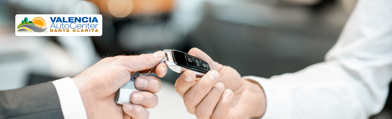 Customer reviewing certified pre-owned car features at Valencia Auto Center showroom