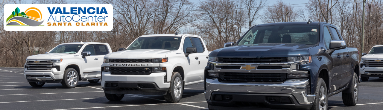 Valencia Auto Center showcasing lineup of used trucks for sale.