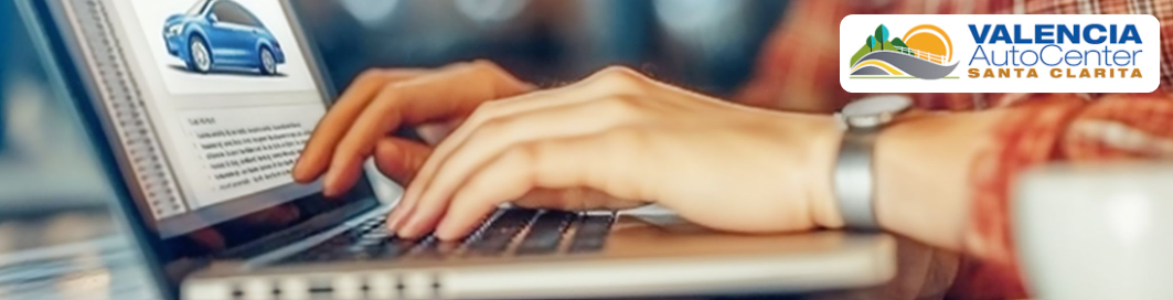  Friendly salesperson at Valencia Auto Center assisting a customer with auto financing options in Valencia, CA.