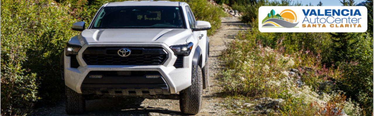Happy customer reviewing Tacoma lease options with a sales consultant at Valencia Auto Center in Southern California.