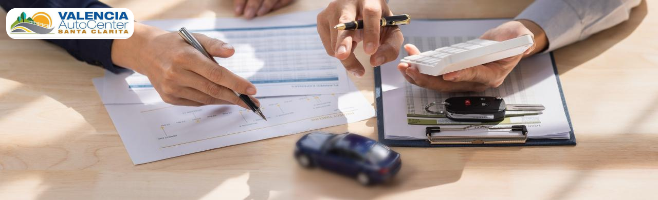 Dealership representative helping a customer use the vehicle lease calculator at Valencia Auto Center