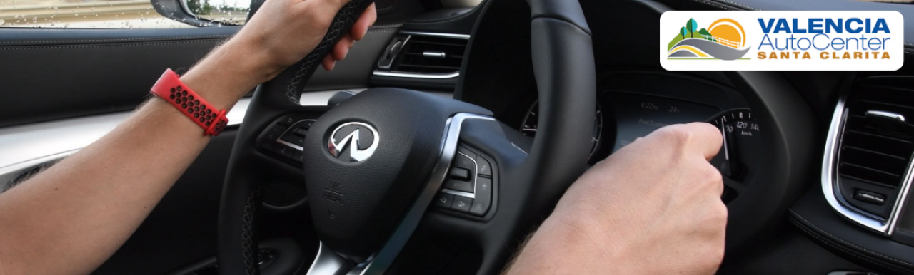 Sales consultant showcasing the interior features of a new INFINITI QX60 to a couple at the dealership.