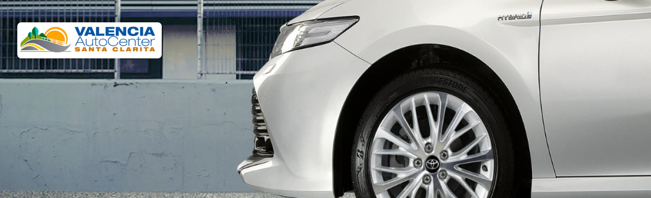 Toyota Camry Hybrid sedan parked in dealership lot showcasing fuel-efficient hybrid design