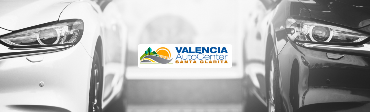 A young couple reviewing a car purchase under $5K with a Valencia Auto Center team member