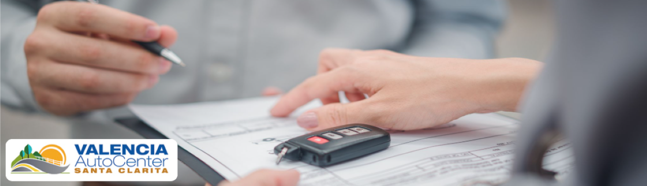 A sales associate assisting a customer with financing options at the Dodge section of Valencia Auto Center.