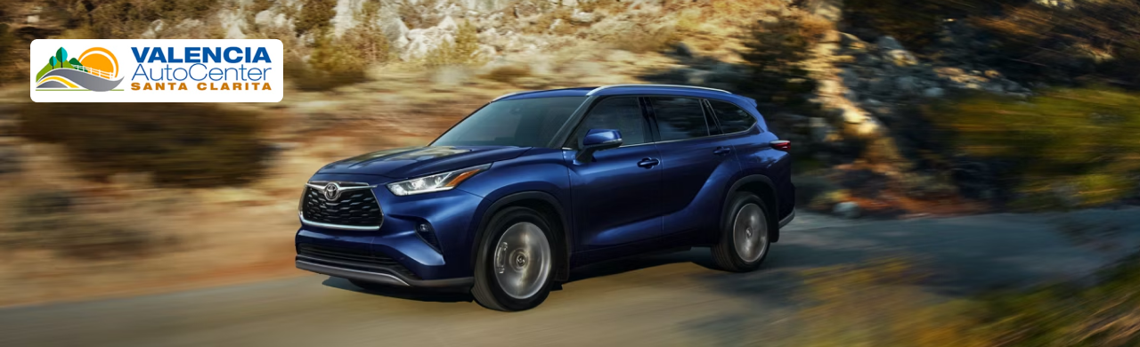 Family exploring the interior of a pre-owned Highlander Hybrid while shopping at Valencia Auto Center.