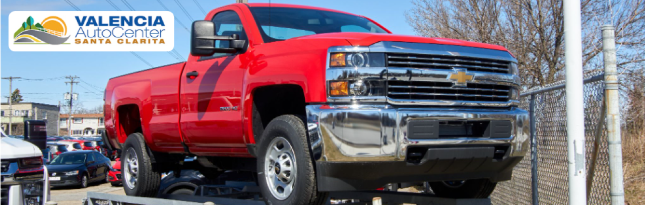 A customer viewing light-duty and heavy-duty used trucks available at Valencia Auto Center, showcasing dealership variety.